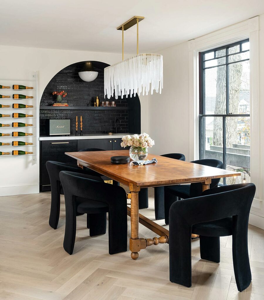 View into the open plan dining room with decorative chandelier and an arched alcove.