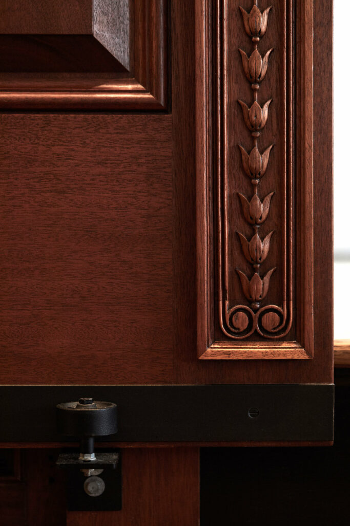 Detail of the woodwork showing a flower pattern in wood trim around a door